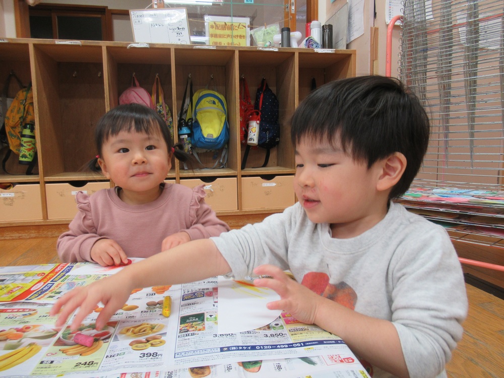 クレヨンで模様を描いている子どもたち