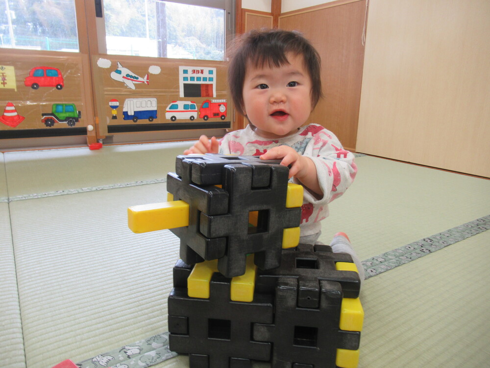 ブロックを積み重ねて喜ぶ子ども