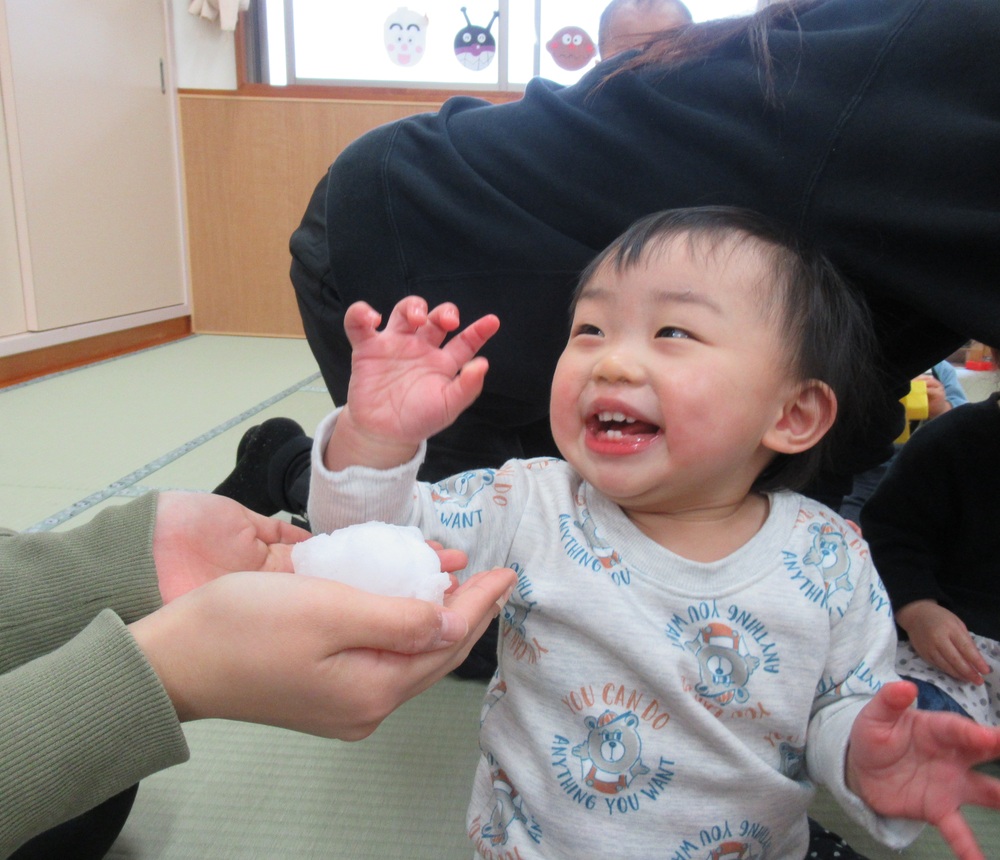 雪に触れてニコニコな子ども