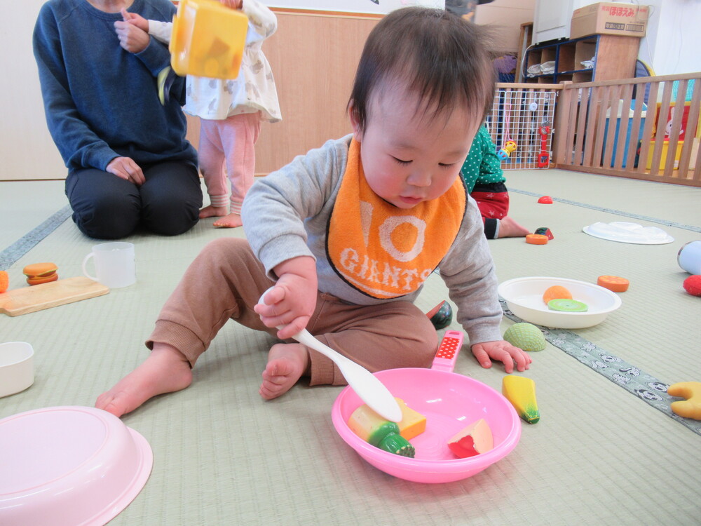 しゃもじを使って料理をする子ども