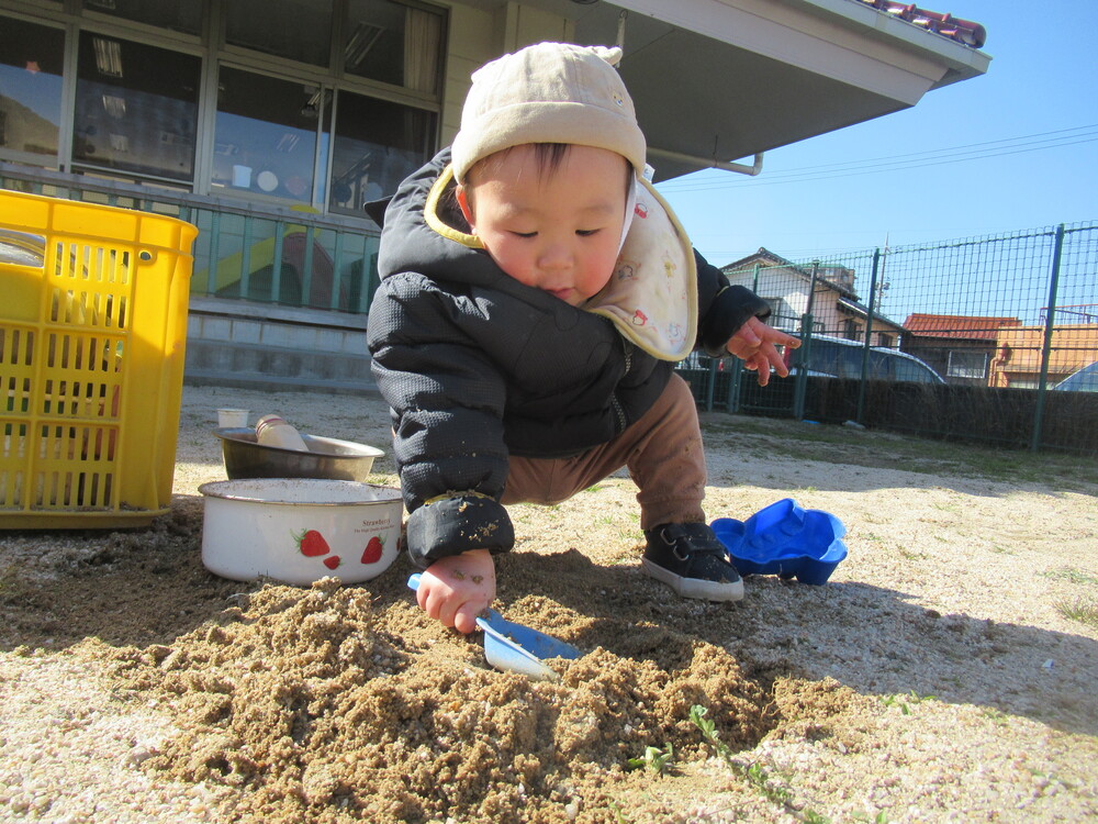 男の子が砂で遊んでいる