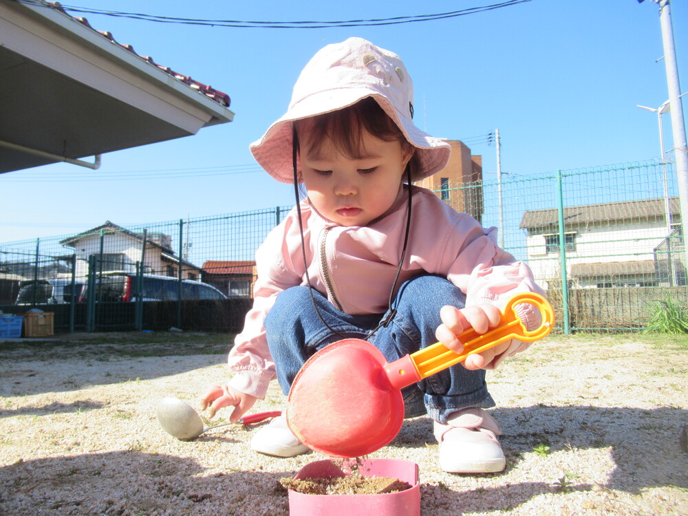 女の子がスコップで砂を掘っている
