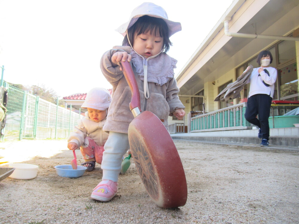 女の子がフライパンを持っている