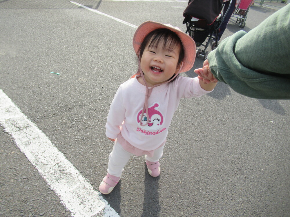 保育者と手を繋いで歩く子ども