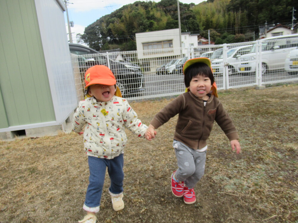 手を繋いで走っている男の子と女の子