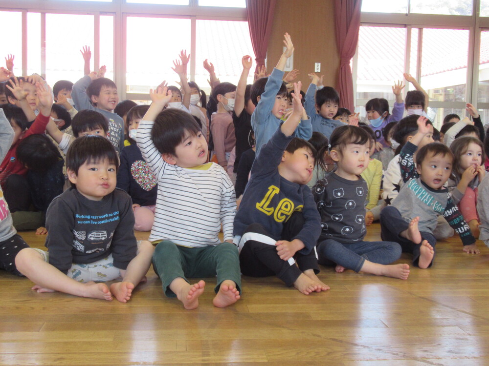 保育者の出し物を見ている子どもたち