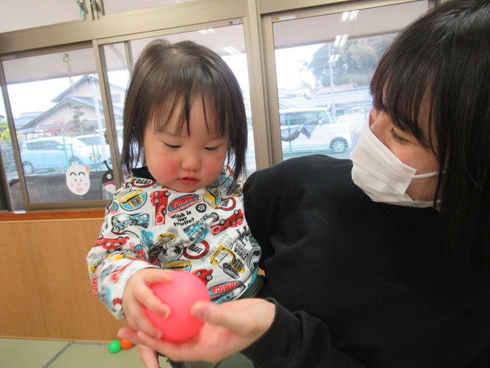 男の子が保育者からボールを貰っている