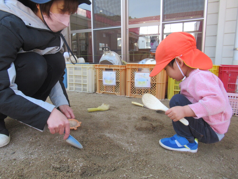 保育者と型抜きをする男の子