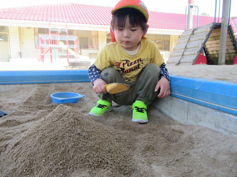 砂場でお山を作っている男の子
