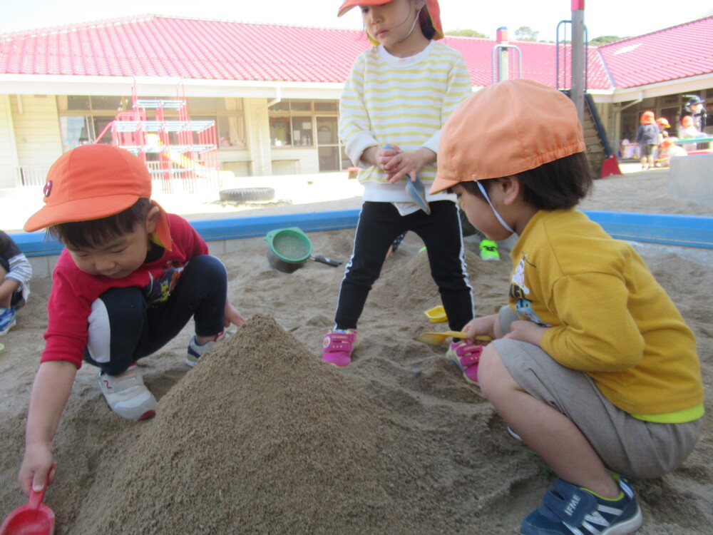砂場でお山を作っている子どもたち