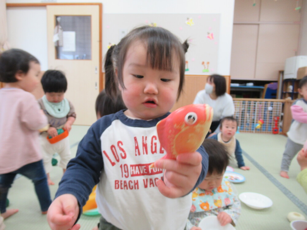 魚を保育者に見せる