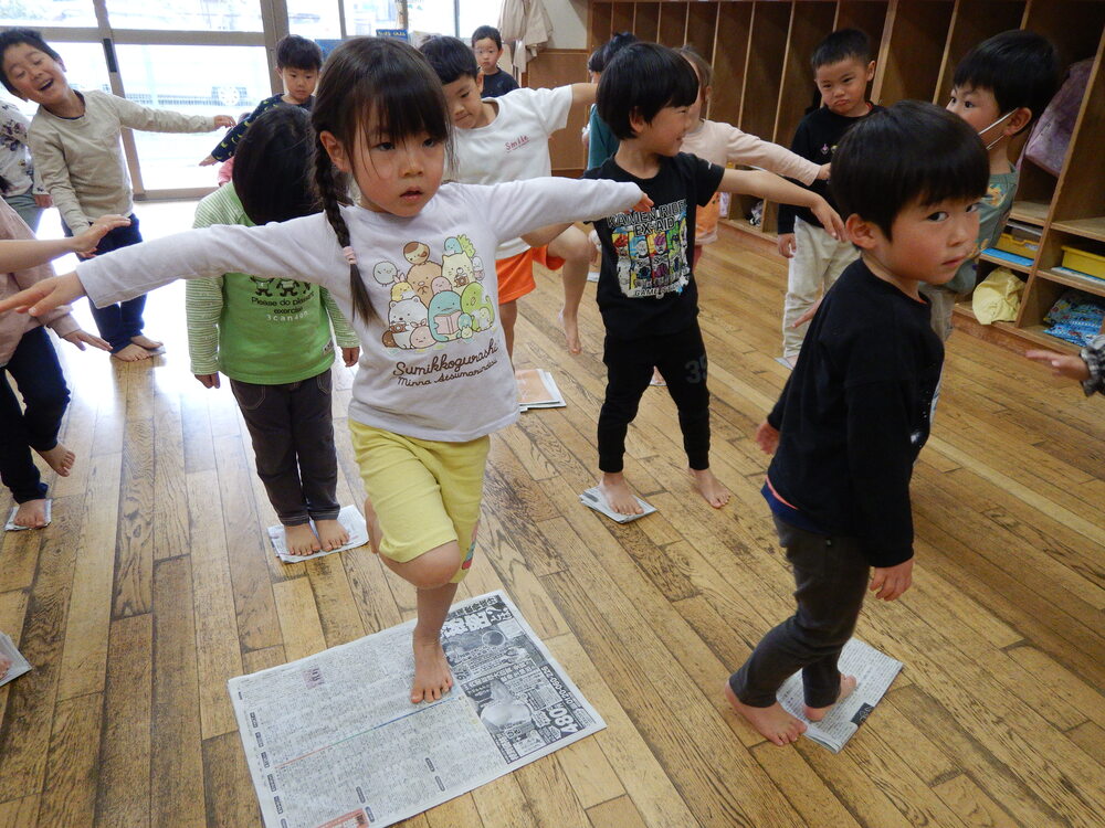 折った新聞の上に立っている