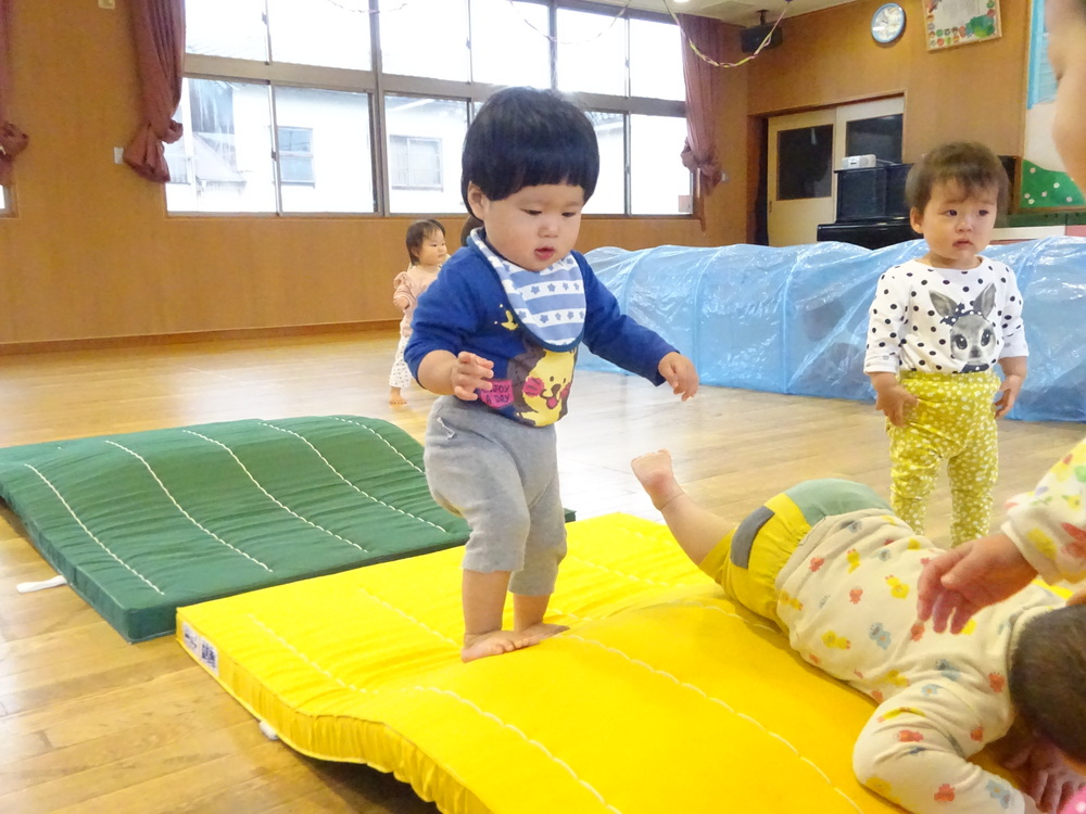 マットの山を歩く男の子