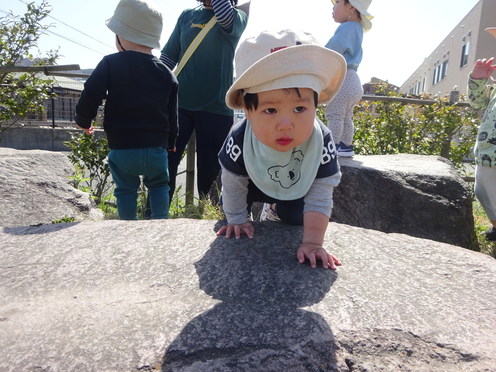 石に登ろうとしている男の子