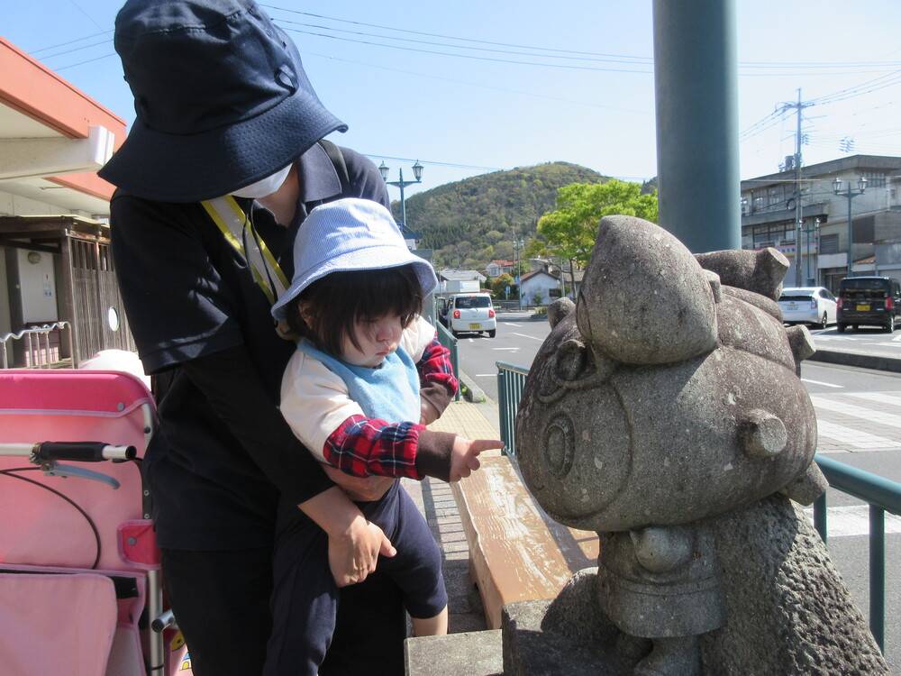 らとちゃんの石像を見ている