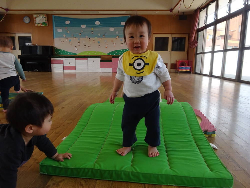 マットの山で遊ぶ男の子