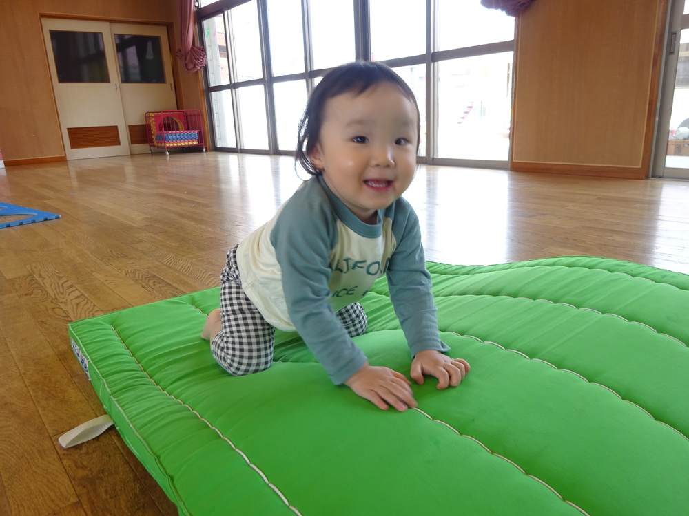 マットの山で遊ぶ女の子