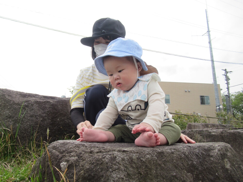 男の子が石の上に座っている