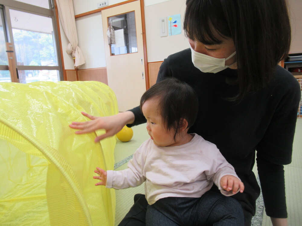 トンネルに触れて遊ぶ子ども