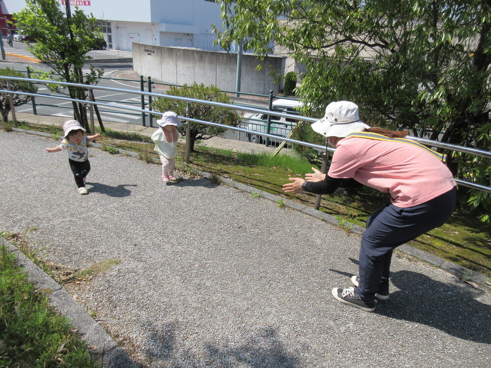 保育者と追いかけっこをしている