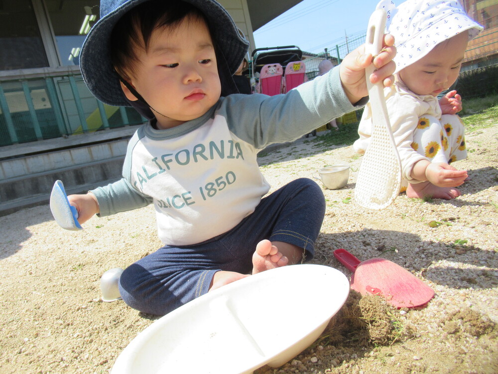 しゃもじとスコップを持って遊んでいる子ども