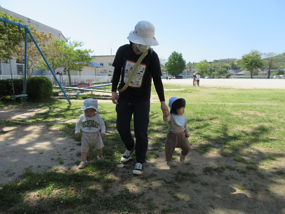 保育者と手をつないで歩いている