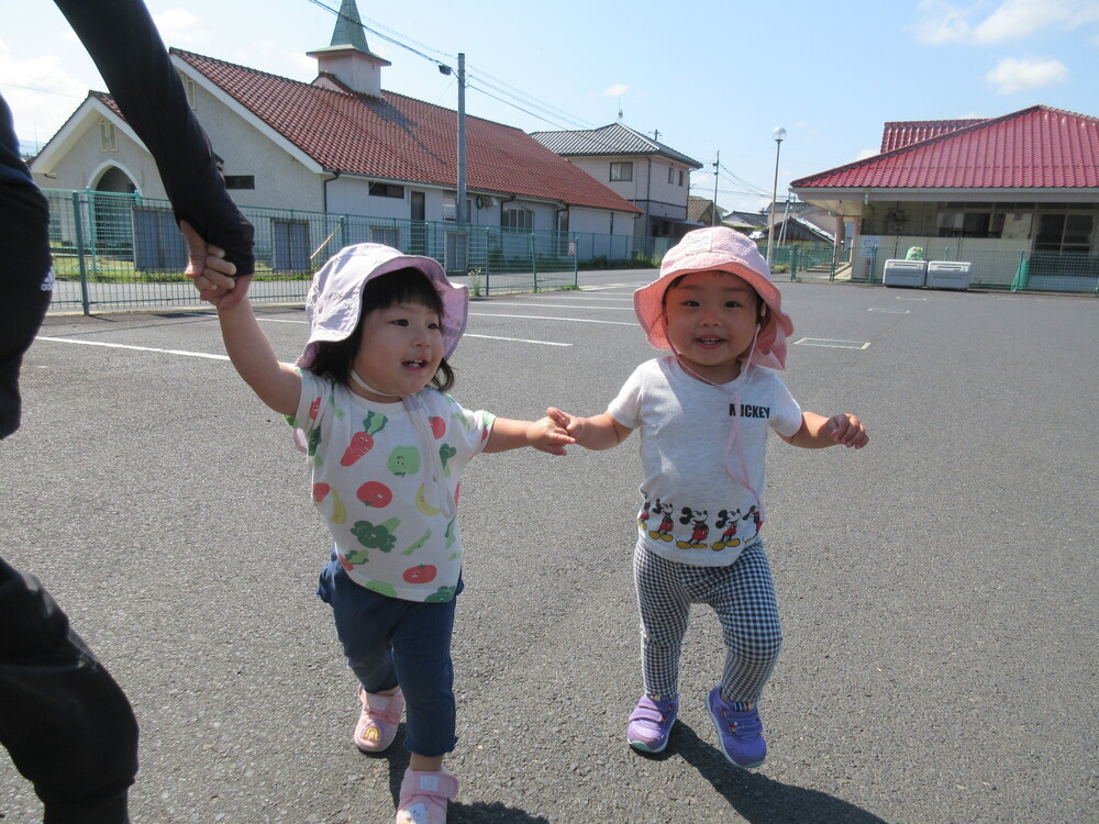 女の子が手を繋いで歩いている