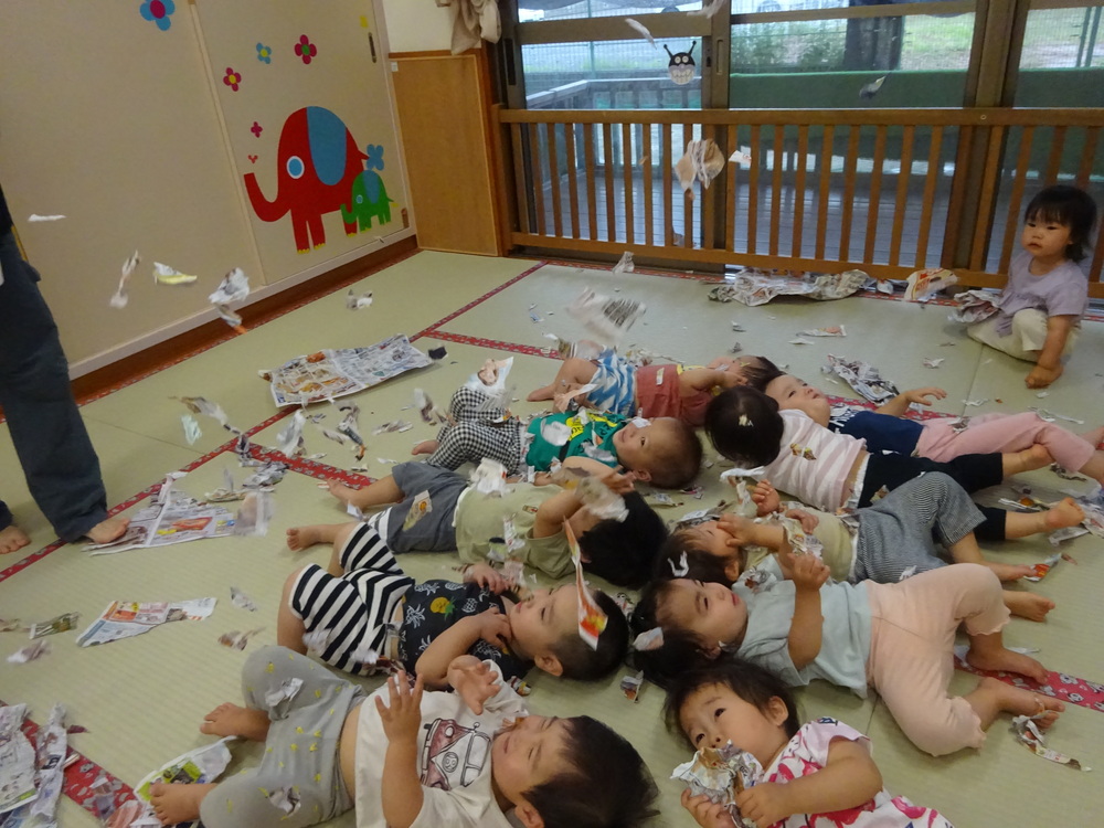 広告紙で遊ぶ子ども