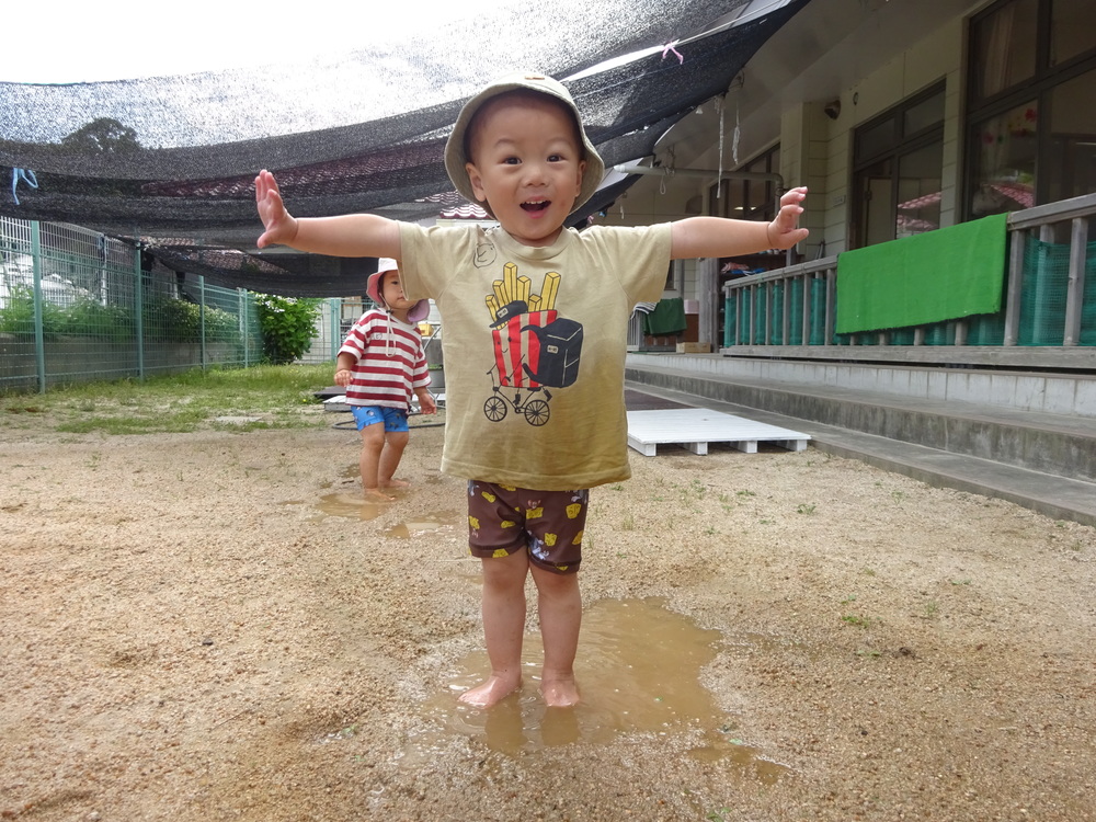 水たまりで遊んでいる男の子