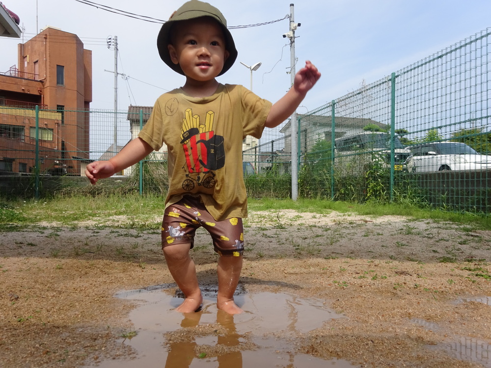 水たまりで遊ぶ男の子