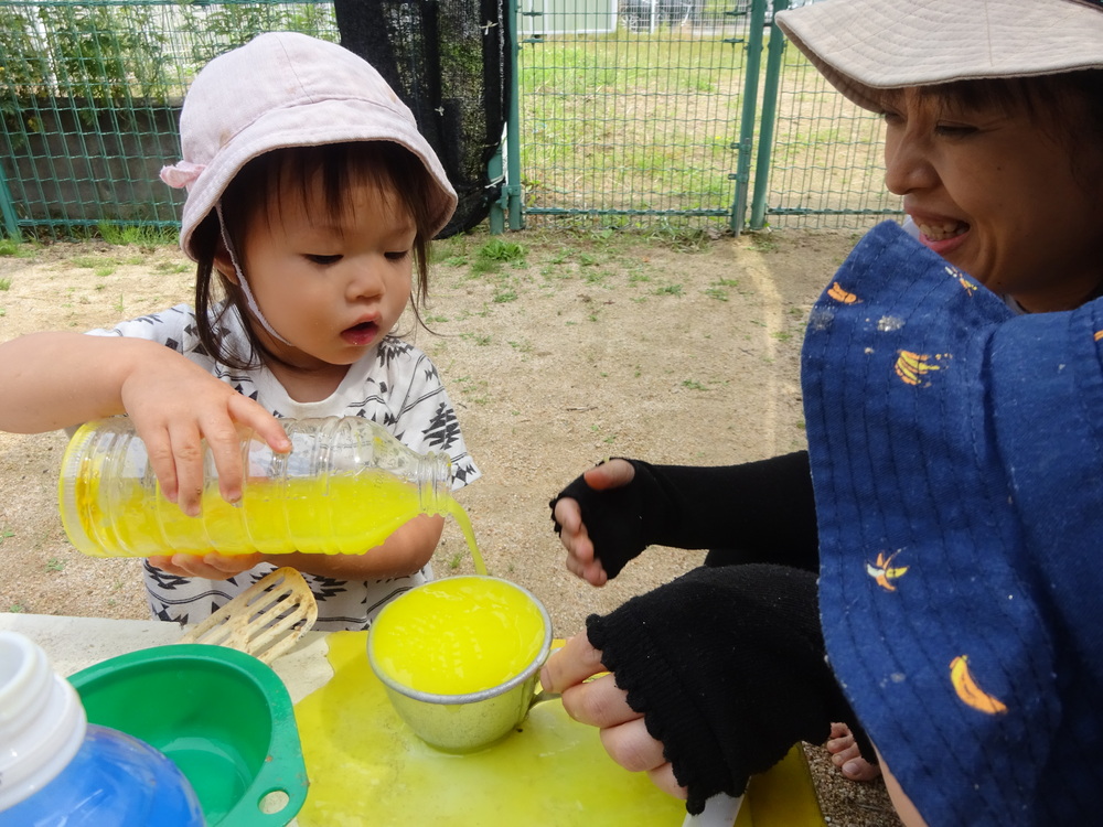 コップに色水を入れる女の子