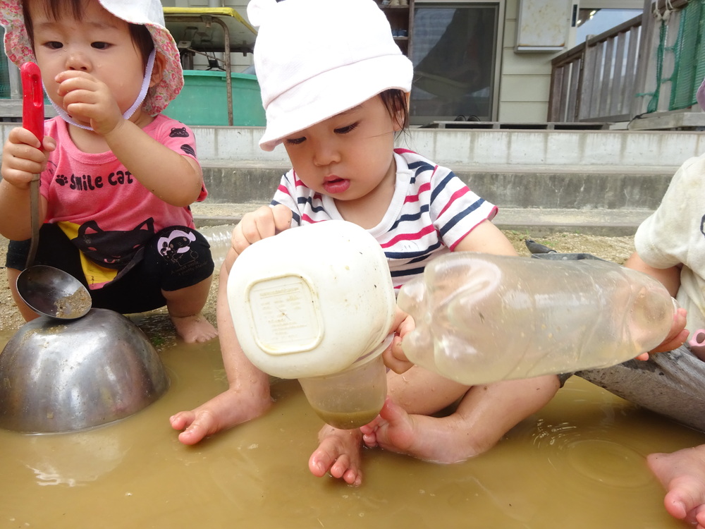 水たまりで遊ぶ女の子