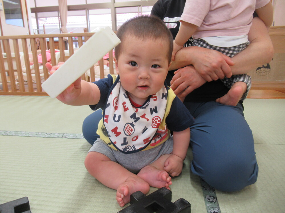 男の子がブロックを保育者に見せている
