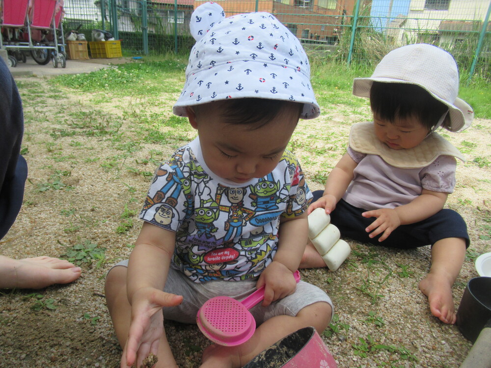 園庭で砂遊びをしている様子