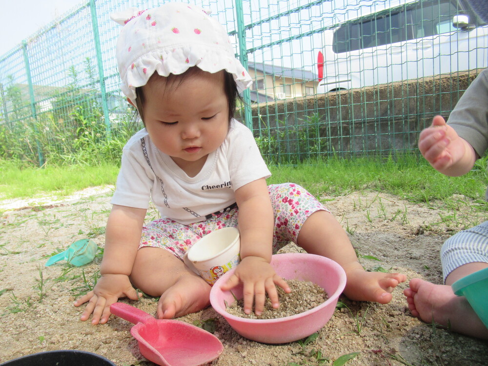 女の子が砂で料理を作っている