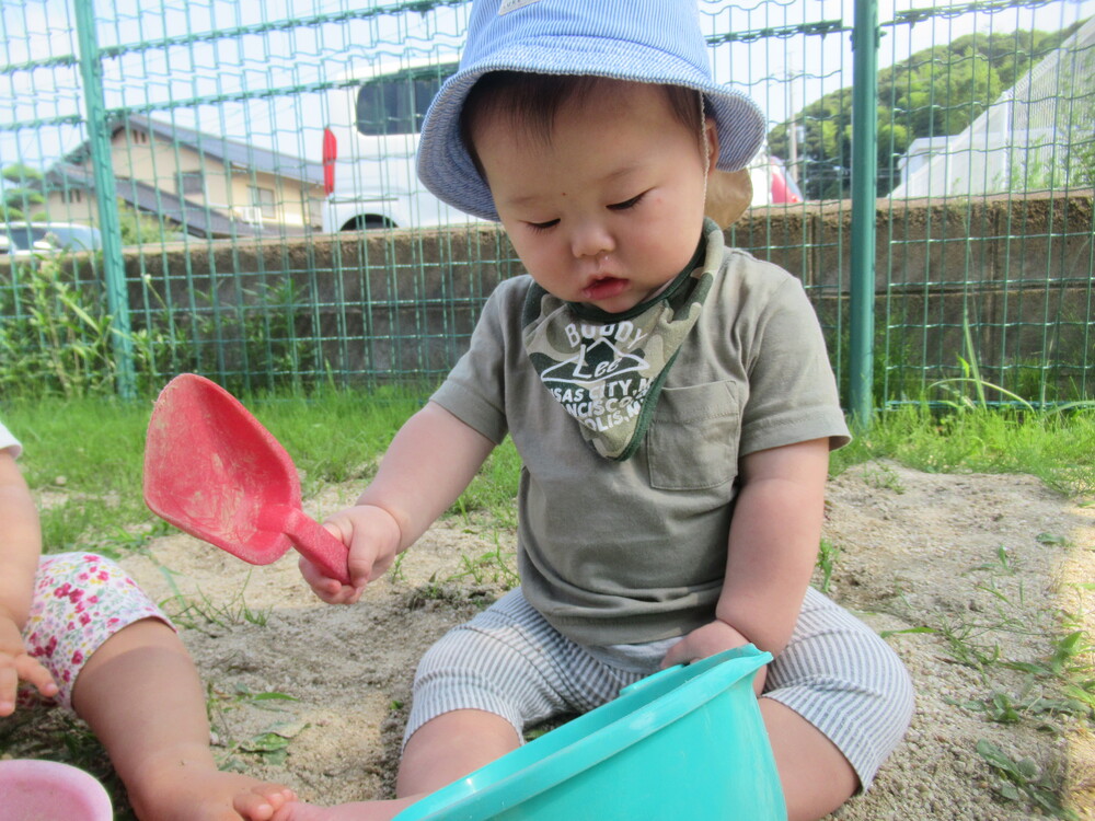 男の子が砂で料理を作っている