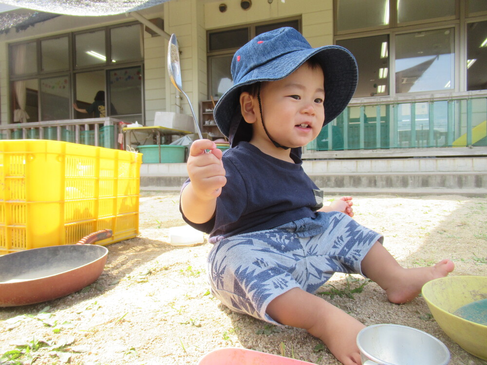 男の子が嬉しそうに砂遊びをしている