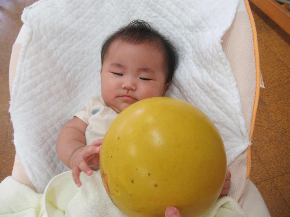 女の子がボールに手を伸ばしている