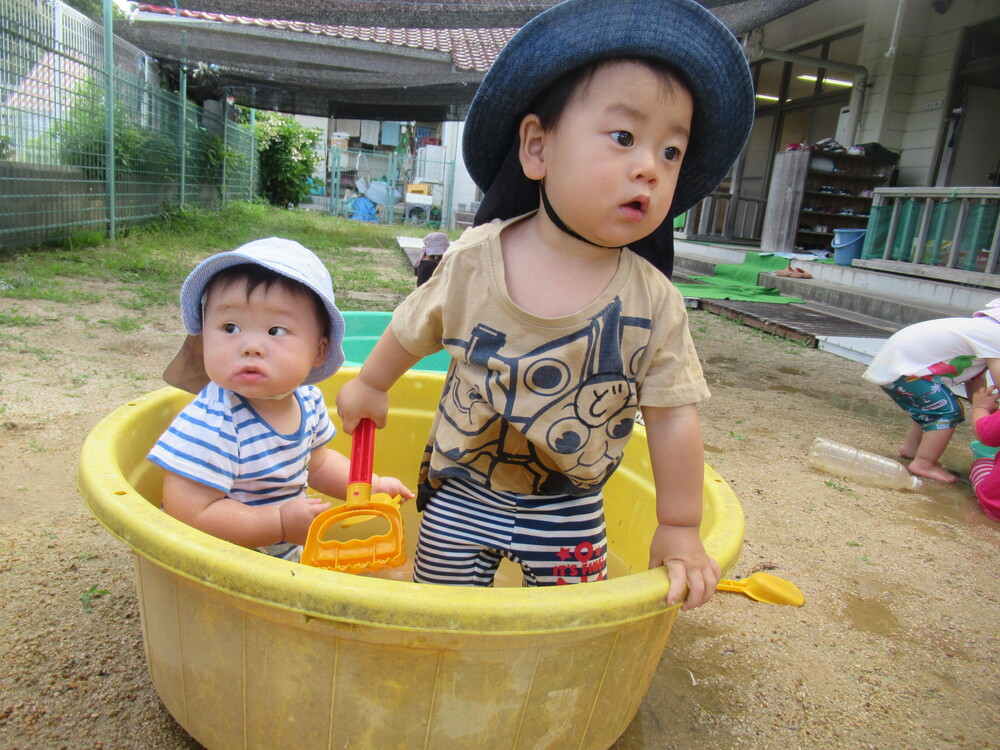 タライの中に入って遊ぶ子どもたち