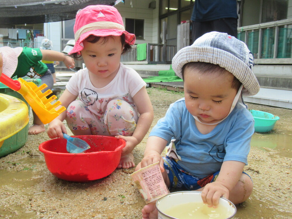 お姉さんと一緒におままごとをする子ども