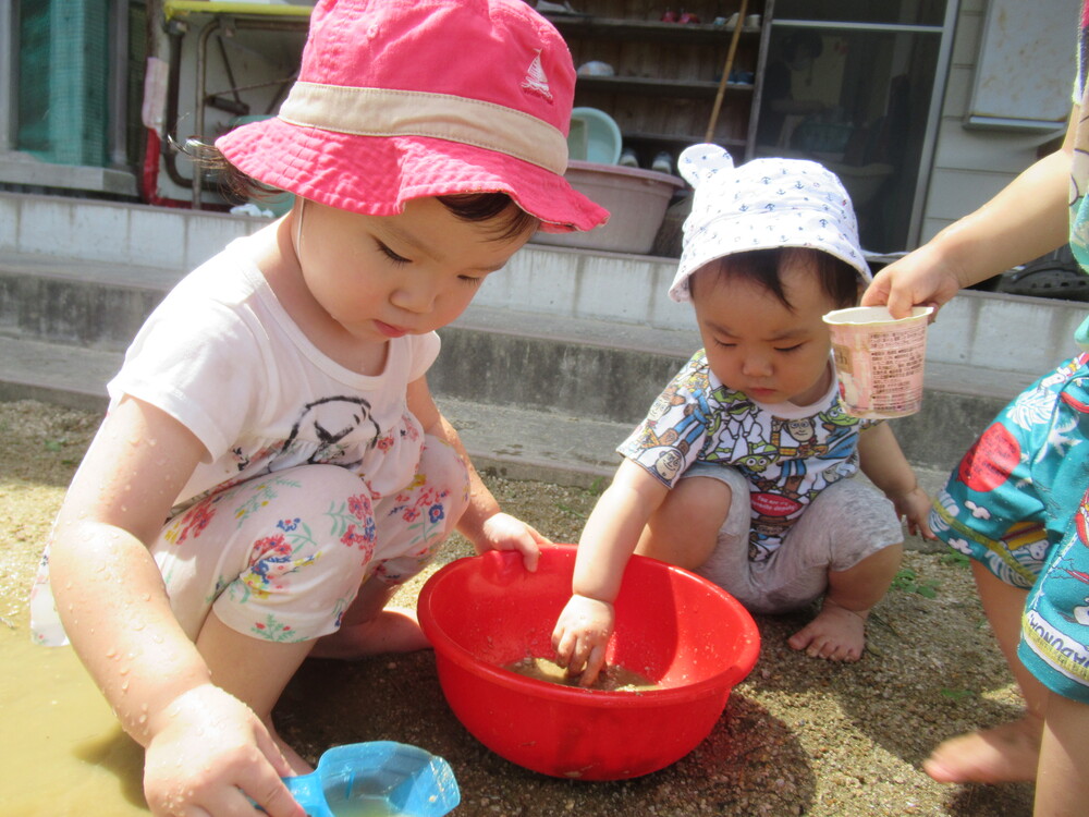 お姉さんと一緒におままごとをする子ども