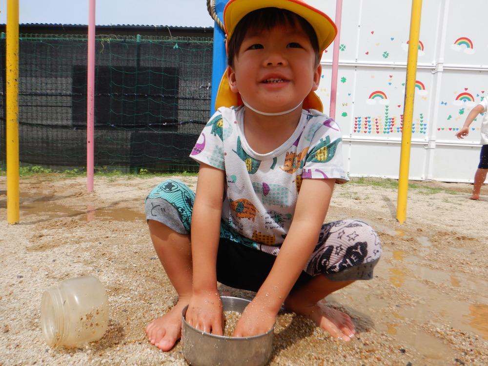 泥んこ遊びを楽しむ男の子