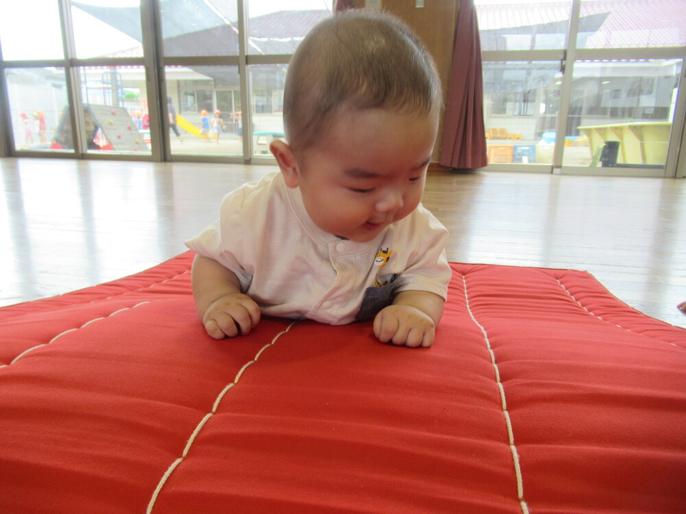 男の子がマットの上でうつ伏せの練習をしている