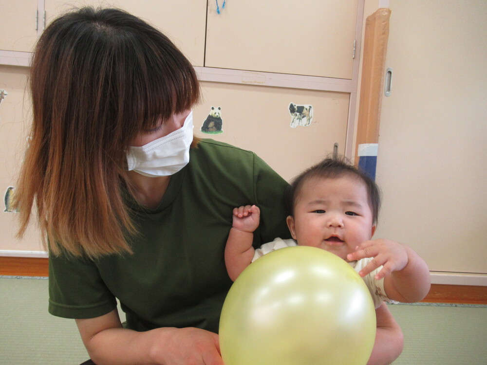 風船を太鼓のようにして遊ぶ子ども