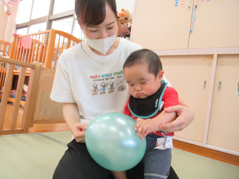 風船にそーっと触れる子ども