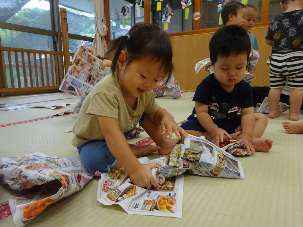 広告紙遊びをしている子ども (1)