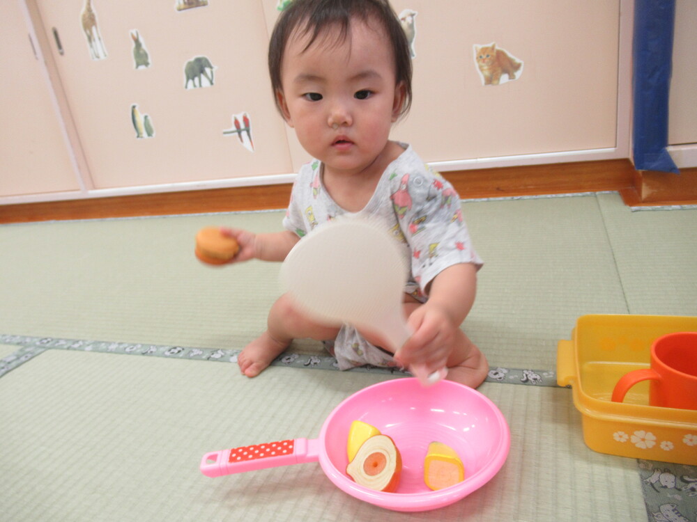 女の子がしゃもじを持って料理をしている