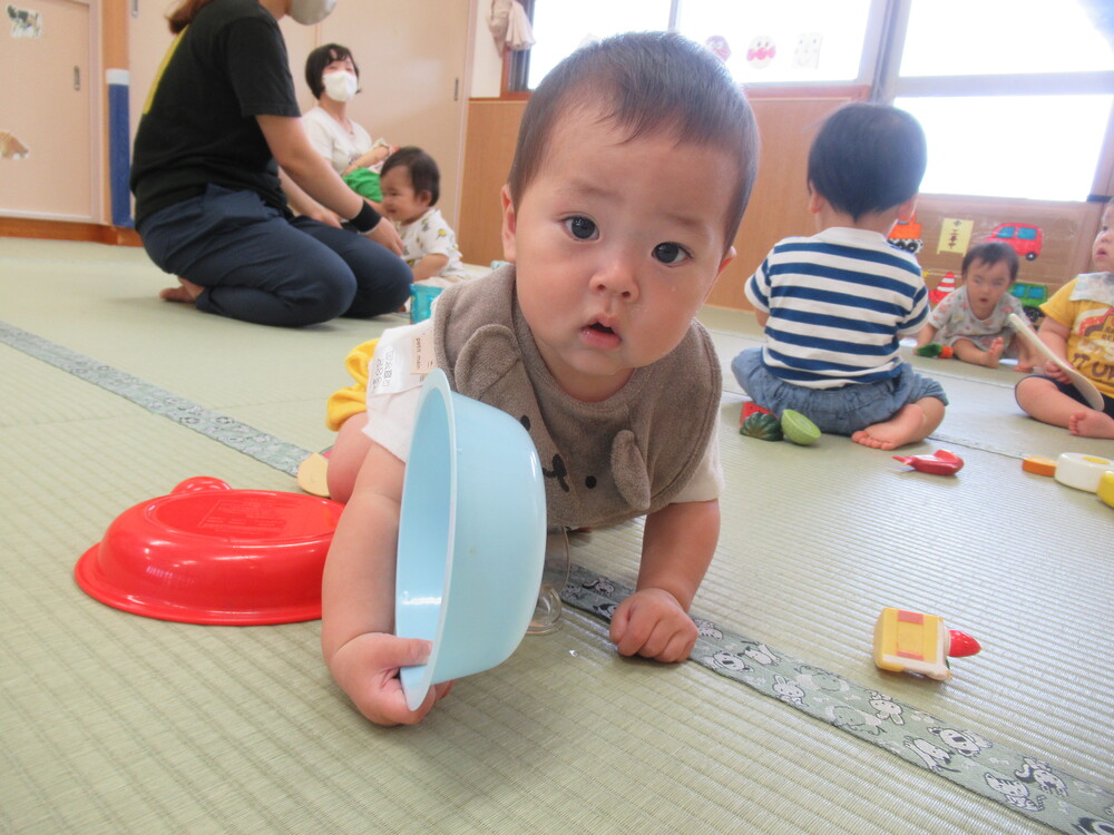 男の子がハイハイしながら皿を持っている