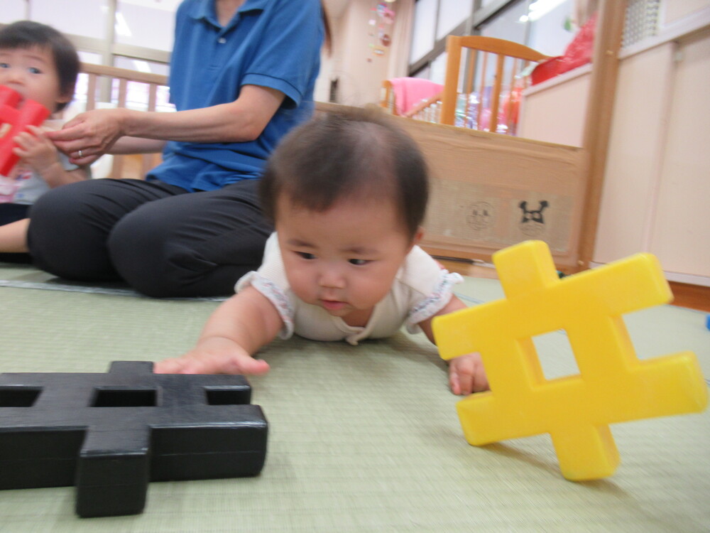 井形ブロックに手を伸ばしている子ども