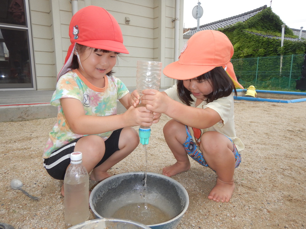 友だちと水遊びをしている